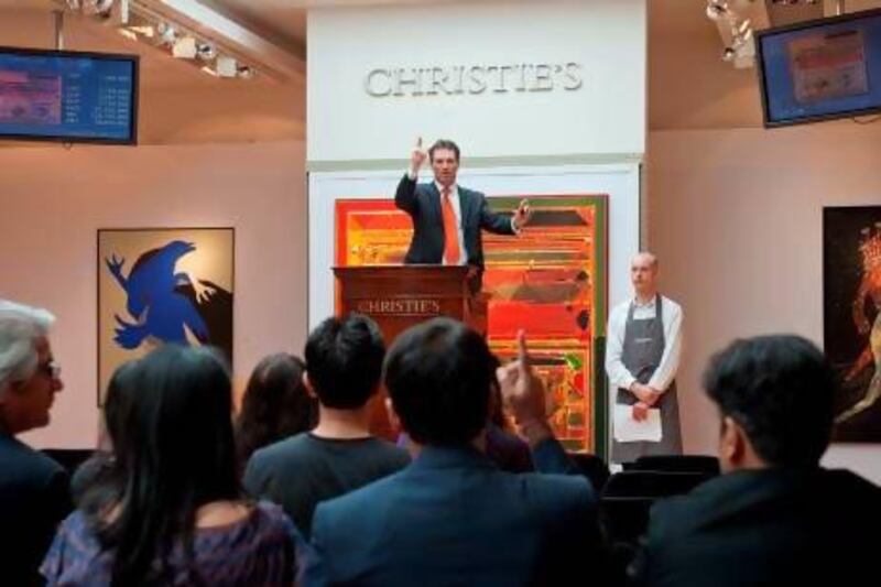 Auctioneer Hugo Weihe takes bids during the sale of "Saurashtra" by Indian artist Syed Haider Raza.