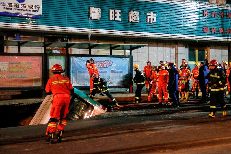 Chinese rescuers prepare to lift a bus out of the sinkhole. AFP