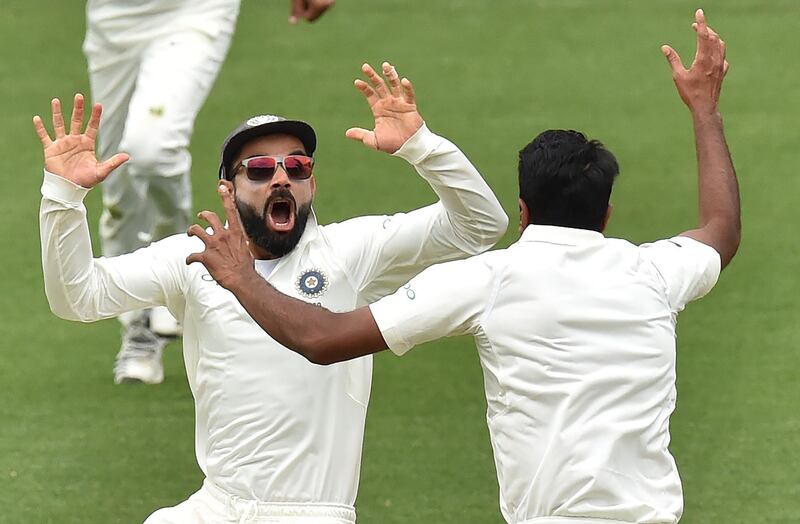 India's captain Virat Kohli (L) celebrates with spin bowler Ravichandran Ashwin (R) after beating Australia  on day five of the first Test cricket match at the Adelaide Oval on December 10, 2018. / AFP / PETER PARKS
