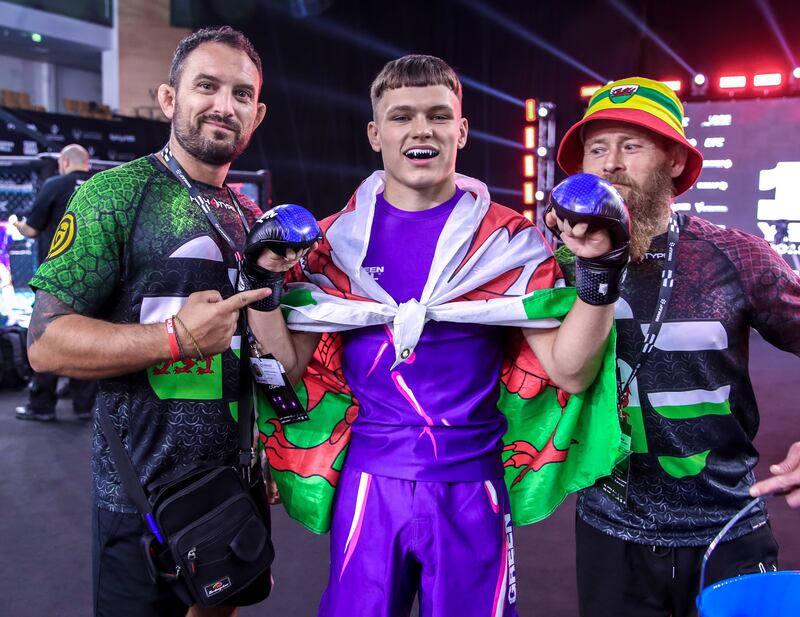 Ethan Mayhew of Wales celebrates with his coaches after his win in the lightweight division. 