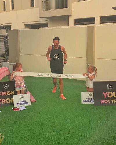 Lee Ryan crosses a homemade finish line, with the support of his daughters, Lily and Sophia. Courtesy Lee Ryan 