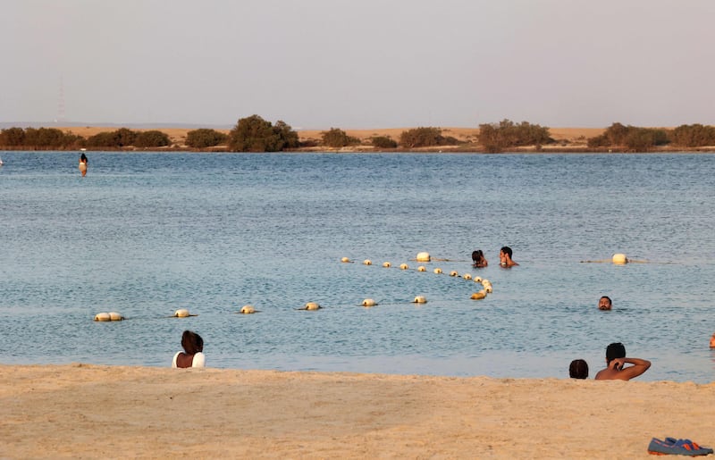 People swim at Pure Beach in King Abdullah Economic City.