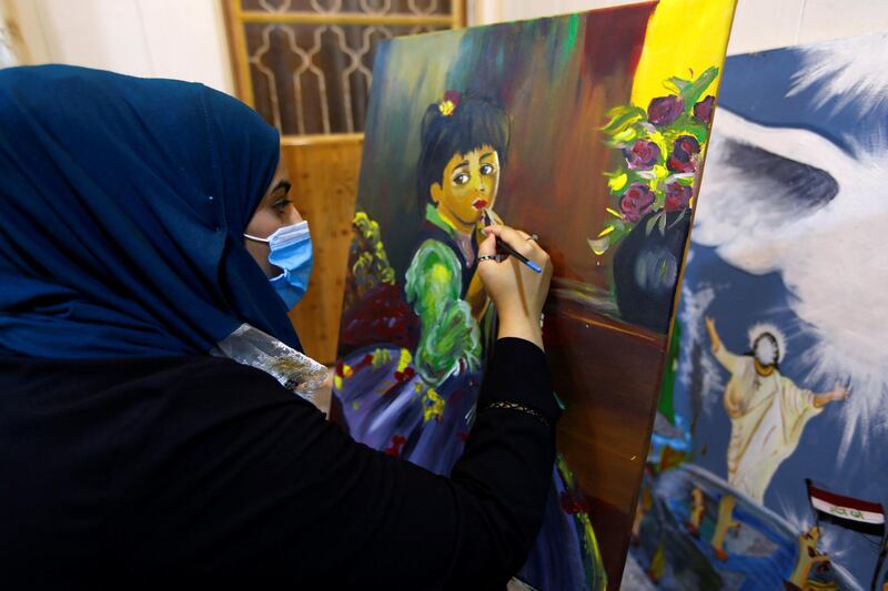 An Iraqi girl wears a protective mask as she works on an oil painting at her home, after the government partially lifted the curfew imposed to fight the spread of the coronavirus, in the city of Najaf, Iraq. Reuters