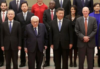 Chinese President Xi Jinping, center left, and Vice Premier Liu He, left, attend a group photo session with former U.S. Secretary of State Henry Kissinger, center left, former U.S. Treasury Secretary Henry Paulson, right, and members of a delegation from the 2019 New Economy Forum before a meeting at the Great Hall of the People in Beijing Friday, Nov. 22, 2019. (Jason Lee/Pool Photo via AP)