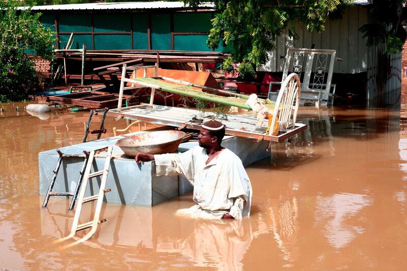 A Sudanese man stands in flood water next to his belongings in Wad Ramli village on the eastern banks of the Nile river.  AFP