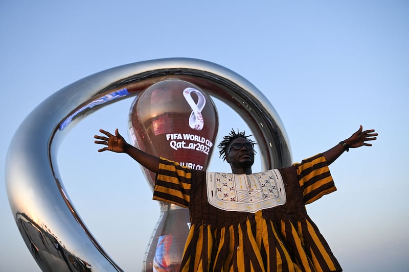 A fan of Ghana's national football team poses beside the Fifa World Cup countdown clock in Doha.  AFP