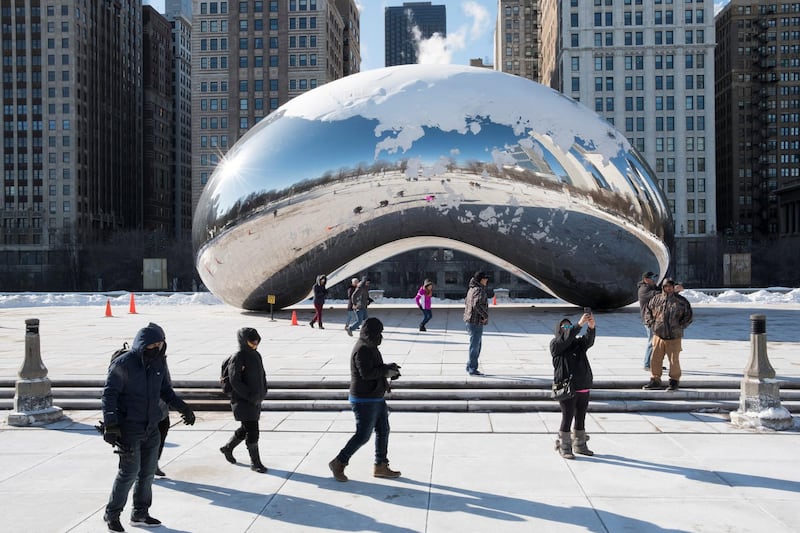 Visitors take photographs in front of the Cloud Gate at Millenium Park during subzero temperatures in Chicago. Reuters