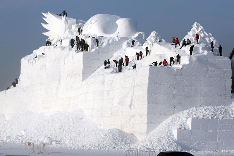 People prepare a snow sculpture for an art expo in Harbin, China. Reuters