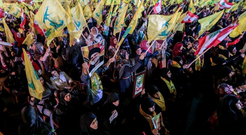 Hezbollah supporters wave flags as they listen to the speech by Hassan Nasrallah in a southern suburb of Beirut. EPA