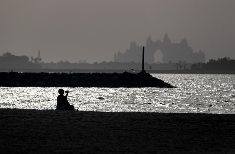Dubai, United Arab Emirates - Reporter: N/A. News. Weather. Summer heat. On a hot and hazy day lady takes a sip of water as she sits on the beach in Dubai. Monday, July 27th, 2020. Dubai. Chris Whiteoak / The National