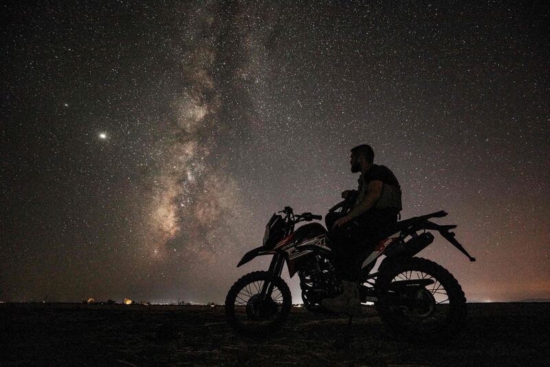 This long-exposure picture taken  shows the Milky Way galaxy rising in the sky above a Syrian fighter of the Turkish-backed National Front for Liberation group on a motorcycle in the town of Taftanaz along the frontlines in the country's rebel-held northwestern Idlib province.  AFP
