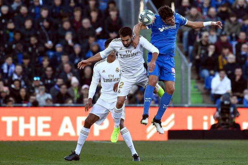 Real Madrid defender Dani Carvajal vies for the ball with Getafe's Jaime Mata on Saturday. AFP