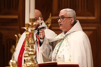 Bishop Paul Abdel Sater, Curial bishop of the Maronite Catholic Patriarchate of Antioch, holds up a crucifix as he speaks during the Christmas Morning mass at the Maronite Cathedral of St George in the capital Beirut's downtown district on Christmas Day on December 25, 2019. (Photo by ANWAR AMRO / AFP)