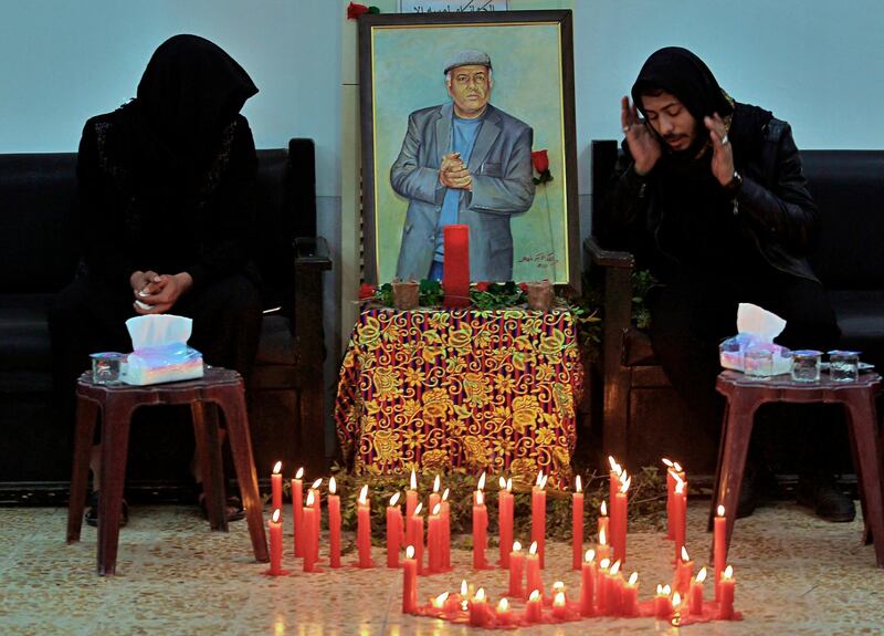 Friends and relatives of Alaa Mashzoub, seen in the poster, pray at his mourning majlis in Karbala, Iraq. Mashzoub, an Iraqi novelist and an outspoken critic of foreign interference in Iraqi affairs, was gunned down this week in Karbala. AP Photo