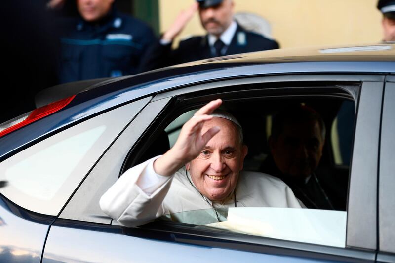 Pope Francis waves from his car as he leaves the "Regina Coeli" prison in Rome after performing the washing the feet of inmates rite on Maundy Thursday. He performed the rite on two Muslims, an Orthodox Christian and a Buddhist. Filippo Monteforte / AFP Photo