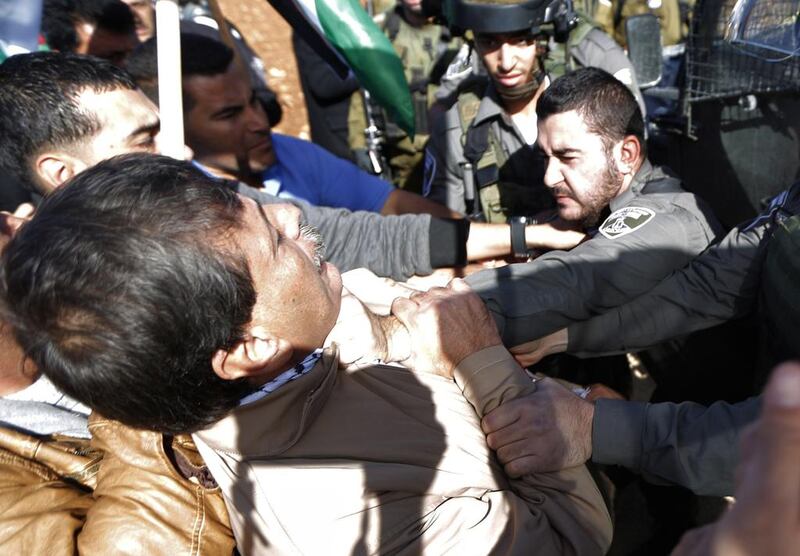 An Israeli border guard grabs Palestinian official Ziad Abu Ein, left, during a demonstration in the village of  Turmus Aya near Ramallah, on December 10, 2014. Abbas Momani / AFP Photo