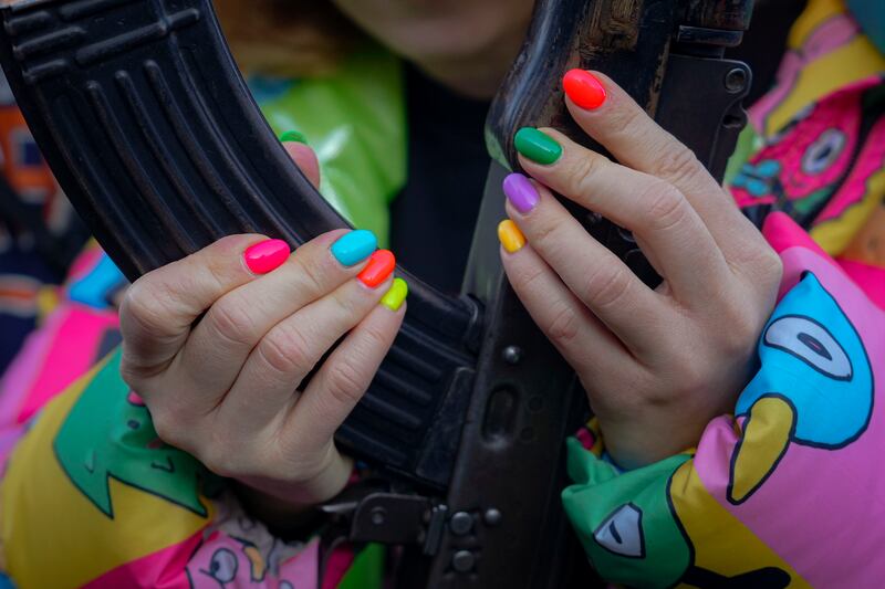 A young woman handles a weapon during basic combat training for civilians, in Mariupol. AP