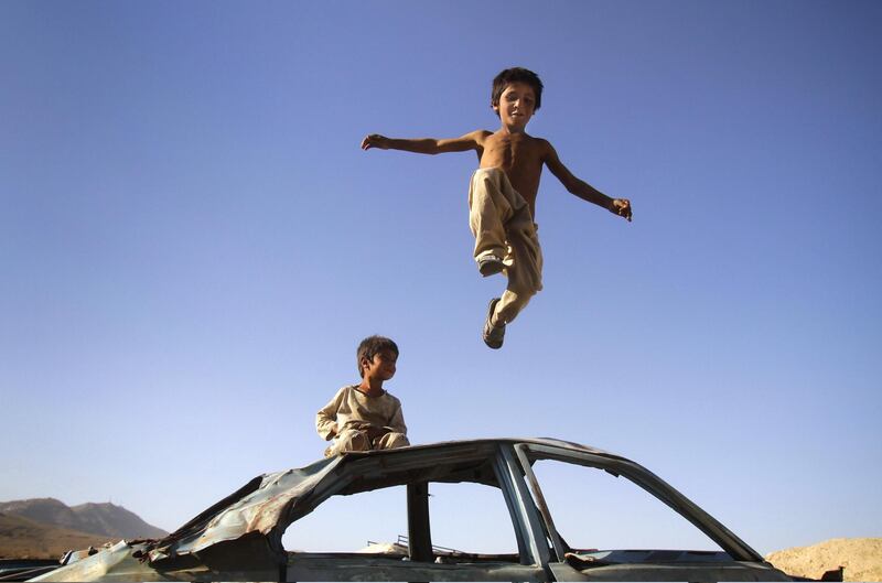 An Afghan boy jumps down from a vehicle in Kabul, Afghanistan, Thursday, July, 5, 2012. (AP Photo/Ahmad Jamshid)