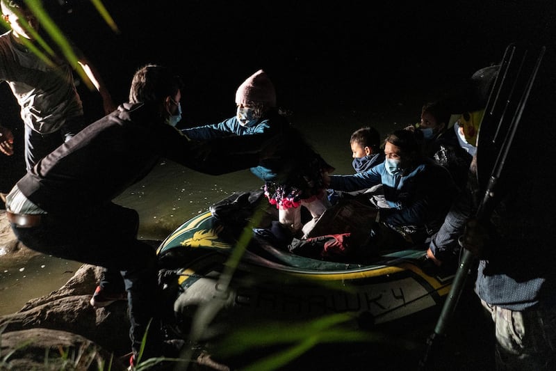 Asylum-seeking migrant families disembark from an inflatable raft after crossing the Rio Grande river into the United States from Mexico, in Roma, Texas, U.S., May 7, 2021. REUTERS/Go Nakamura