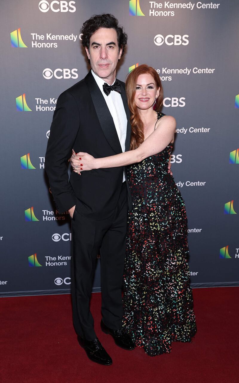 Sacha Baron Cohen and Isla Fisher, wearing a sequinned gown. AFP