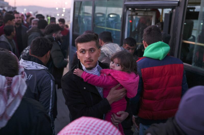 Syrian refugees living in Turkey take a bus through the northern Bab al-Hawa border crossing, on February 17, 2023, as they return to Syria in the aftermath of a deadly earthquake.  - Turkey this week allowed Syrians under its protection who hold ID cards from one of the quake-hit provinces to leave for between three and six months, a rule change designed to reunite families on both sides of the border hit by the February 6 disaster, which has killed more than 41,000 people and displaced millions across both countries.  (Photo by Omar HAJ KADOUR  /  AFP)