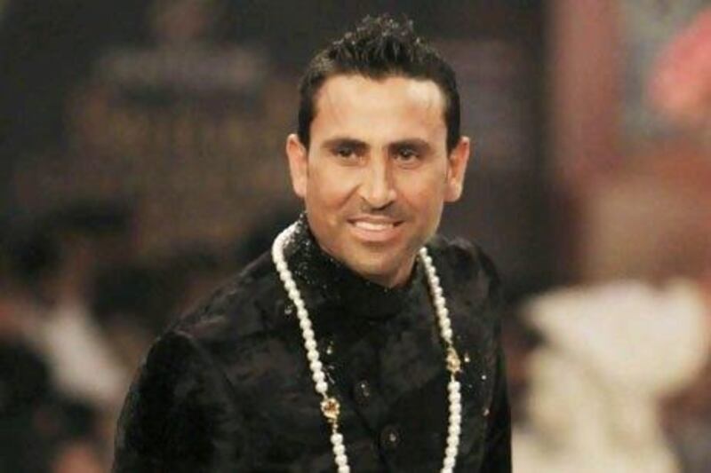 The Pakistani test cricketer Younis Khan presents a creation during Bridal Couture Week in Karachi.