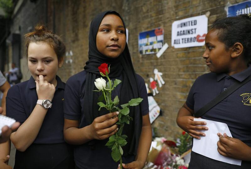School children arrive to lay flowers in tribute to the victims of a van attack in the Finsbury Park area of north London. Tolga Akmen / AFP