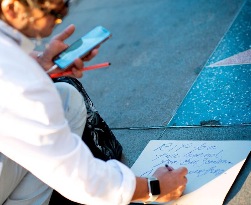 Fans write tributes for Stan Lee at his star on the Hollywood Walk of Fame. AFP