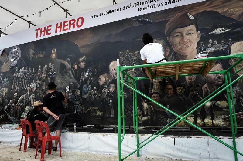 Artists work on a mural dedicated to the successful rescue of the 'Wild Boars" football team.  AFP Photo