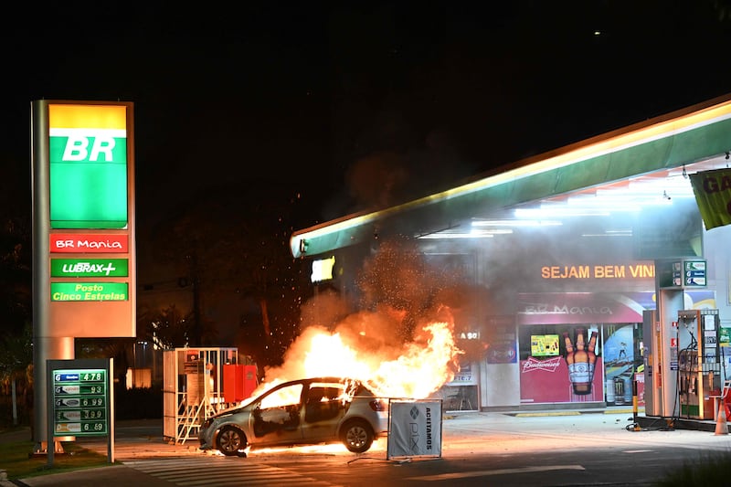 A car burns at a petrol station after clashes between riot police and supporters of Jair Bolsonaro in Brasilia. AFP