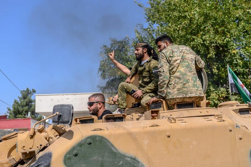 Turkey-backed Syrian National Army (SNA) fighters drive in Sanliurfa, on October 18, 2019 as they head for Akcakale border town to reach Tal Abyad in Syria.  Sporadic clashes between Turkish forces and Kurdish groups were ongoing in a battleground Syrian border town on October 18, a monitor said, despite Ankara's announcement of a five-day truce.  / AFP / BULENT KILIC
