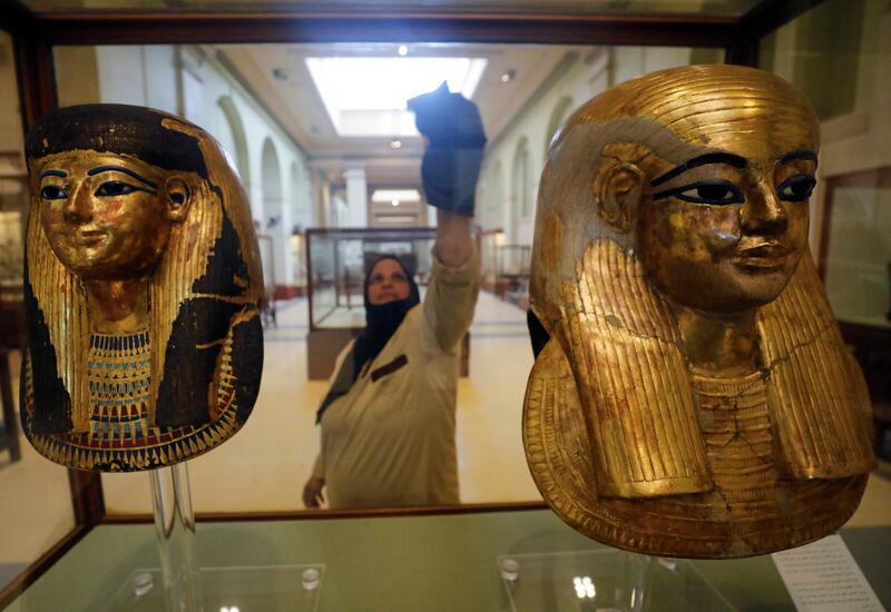 A worker cleans the display glass of ancient pharaoh masks as tourists visit the Egyptian Museum at Tahrir Square after its reopening in Cairo, Egypt. Reuters