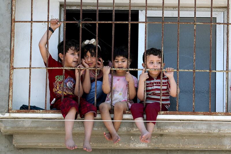 Children watch a rally through a home window fence in Gaza City as Palestinians call for a 'day of rage' to protest against Israel's plan to annex parts of the Israeli-occupied West Bank. Reuters