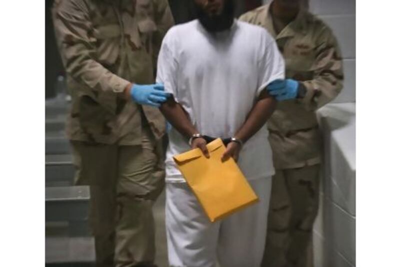 US military guards with a detainee at the US Detention Centre in Guantanamo Bay, Cuba.
