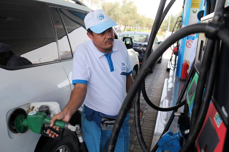 An Adnoc attendant is seen filling a car with petrol in Abu Dhabi. Petrol prices in the UAE have reflected the trend in the global oil market. Sammy Dallal / The National