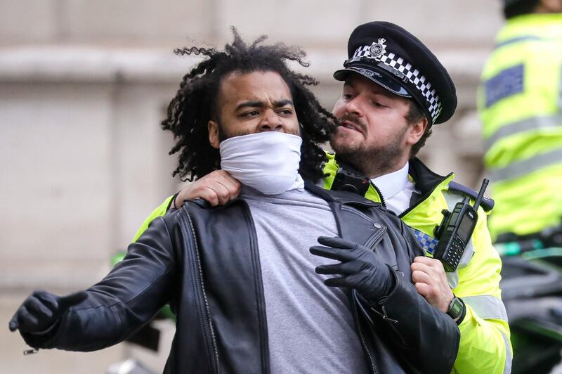 A police officers grabs a demonstrator to prevent him from fighting with an abusive passerby during a rally in Parliament Square in London. AP Photo