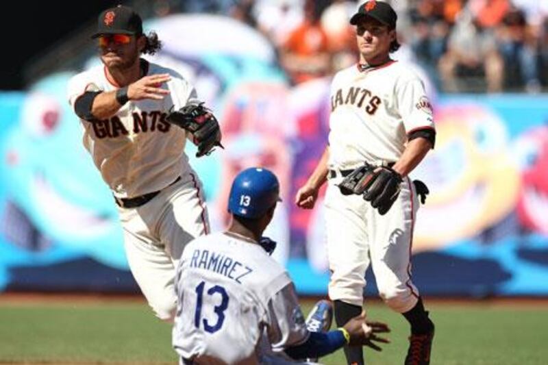 Los Angeles' Hanley Ramirez slides for the plate as Brandon Crawford of the Giants turns a double play.