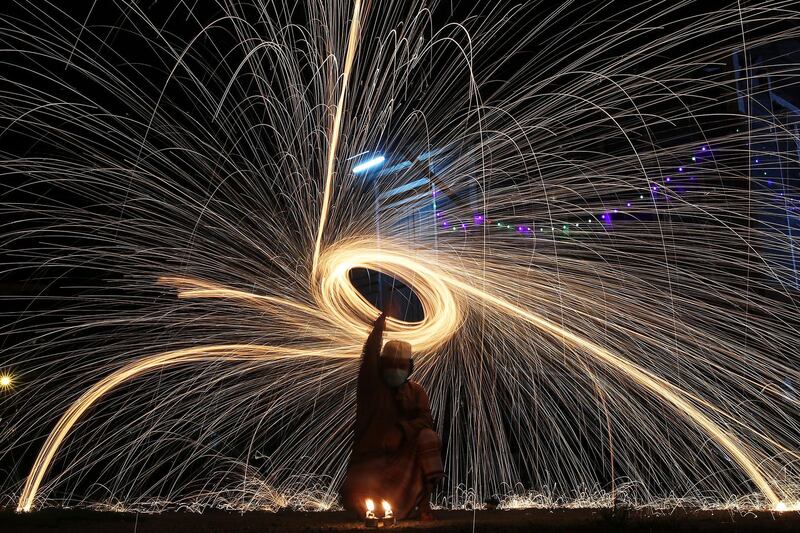 A man swings around fireworks ahead of Eid Al Fitr celebrations, the religious festival that marks the end of Ramadan, amid the ongoing coronavirus pandemic in Klang, outside Kuala Lumpur, Malaysia. EPA