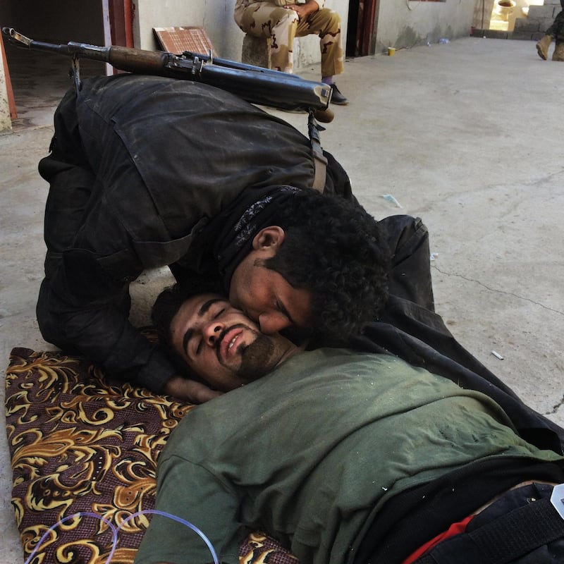 WARDAK, IRAQ: A peshmerga comforts his wounded comrade. Photo by  Sebastian Meyer