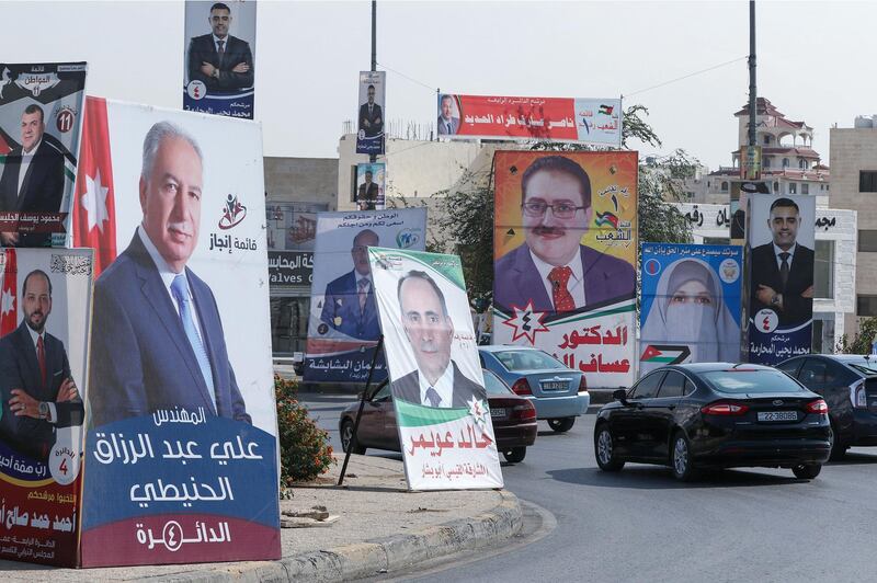 Cars advance on a road lined with campaign banners and slogans of candidates for the upcoming Jordanian parliamentary elections in the capital Amman. AFP