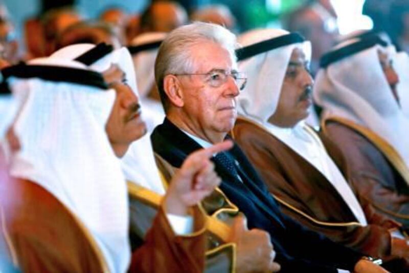 (CQ - Liz) Left to right: HE Sultan bin Saeed Al Mansouri, UAE Minister of Economy, Italian Prime Mario Monti and Abdul Rahman Saif Al Ghurair, the chairman of Dubai Chamber, listen during the UAE-Italy Business Forum at the Dubai Chamber of Commerce and Industry, on November 20, 2012. Monti arrived in the UAE for an official visit to boost the economic ties between the two countries.  AFP PHOTO/MARWAN NAAMANI

