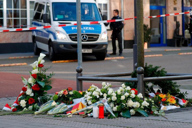 A police car is seen behind flowers placed at a makeshift memorial for the victims of the Hanau shooting in front of a shisha bar in Hanau near Frankfurt am Main, western Germany. Thousands of people took part in vigils across Germany on February 20, 2020, after a gunman with apparent far-right beliefs killed nine people at a shisha bar and a cafe in the city of Hanau on February 19, 2020. The suspect, a 43-year-old German, was found dead at his home after the rampage along with his 72-year-old mother in what appeared to be a murder-suicide. AFP