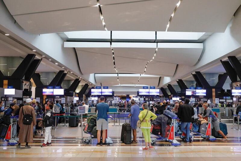 Travellers queue at a check-in counter at OR Tambo International Airport in Johannesburg, after several countries banned flights from South Africa. AFP