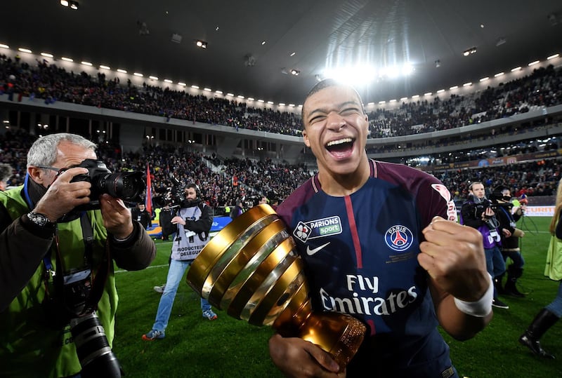 Paris Saint-Germain's French forward Kylian Mbappe reacts with the trophy after winning the French League Cup final football match between Monaco (ASM) and Paris Saint-Germain (PSG) at The Matmut Atlantique Stadium in Bordeaux, southwestern France on March 31, 2018. (Photo by FRANCK FIFE / AFP)