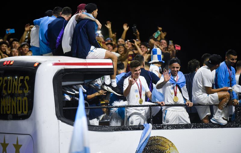 Argentina's Enzo Fernandez, Rodrigo De Paul, Leandro Paredes, Lionel Messi and Julian Alvarez are seen on the open top bus as it arrives at the Argentinian Football Association headquarters. Reuters