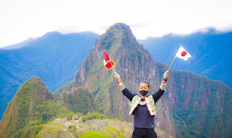 Japanese tourist Jesse Katayama holds a Peruvian and a Japanese flag after becoming the first tourist to visit the ruins of Machu Picchu during the pandemic, in Machu Picchu, Peru. Reuters