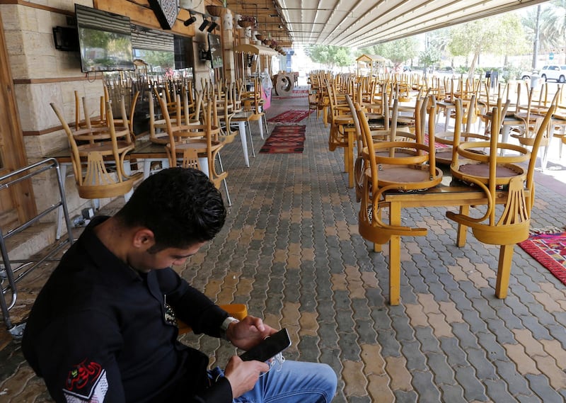 A man uses his mobile phone at an empty cafe in Riyadh, Saudi Arabia. Reuters