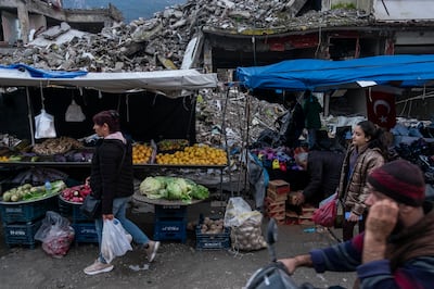 Stallholders in Antakya sell goods among destroyed buildings that use to be shops and homes. Antonie Robertson / The National