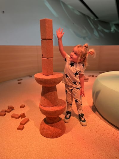 Caspian, 3, builds a tower using the different sized cork blocks in the area for children aged 3 and under. Photo: Gemma White for The National