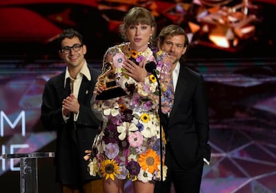Taylor Swift accepts the award for album of the year for "Folklore"at the 63rd annual Grammy Awards at the Los Angeles Convention Center on Sunday, March 14, 2021. In background Jack Antonoff, left, and Aaron Dessner. (AP Photo/Chris Pizzello)